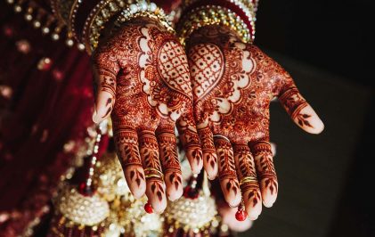 Mehndi wedding ornament on the hands drawn by henna